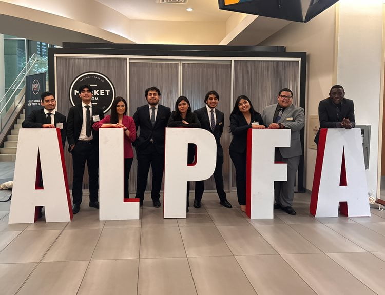 Members of the UTA ALPFA Chapter pose next to a large sign representing the organization. (Courtesy Photo)