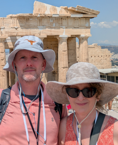 Catherine Hinton and husband pose for a selfie in front of ruins in Athens, Greece.