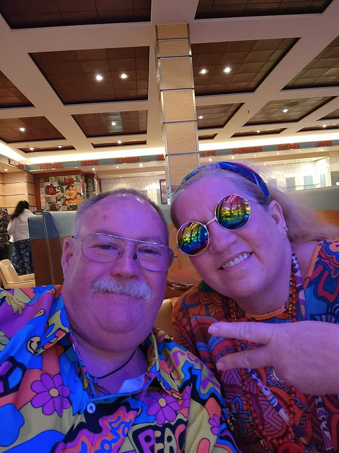 Denise Wylie and husband pose for a selfie in groovy pattern shirts. 