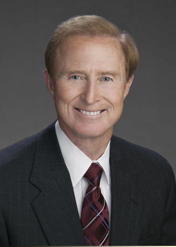 John Merrill smiles while posing for a headshot. 