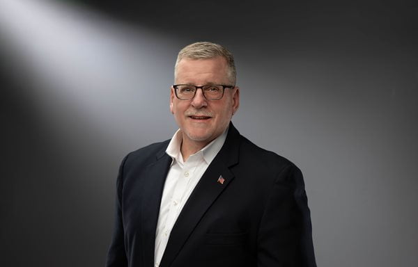 Mike Nalley poses for a photo against a grey background.