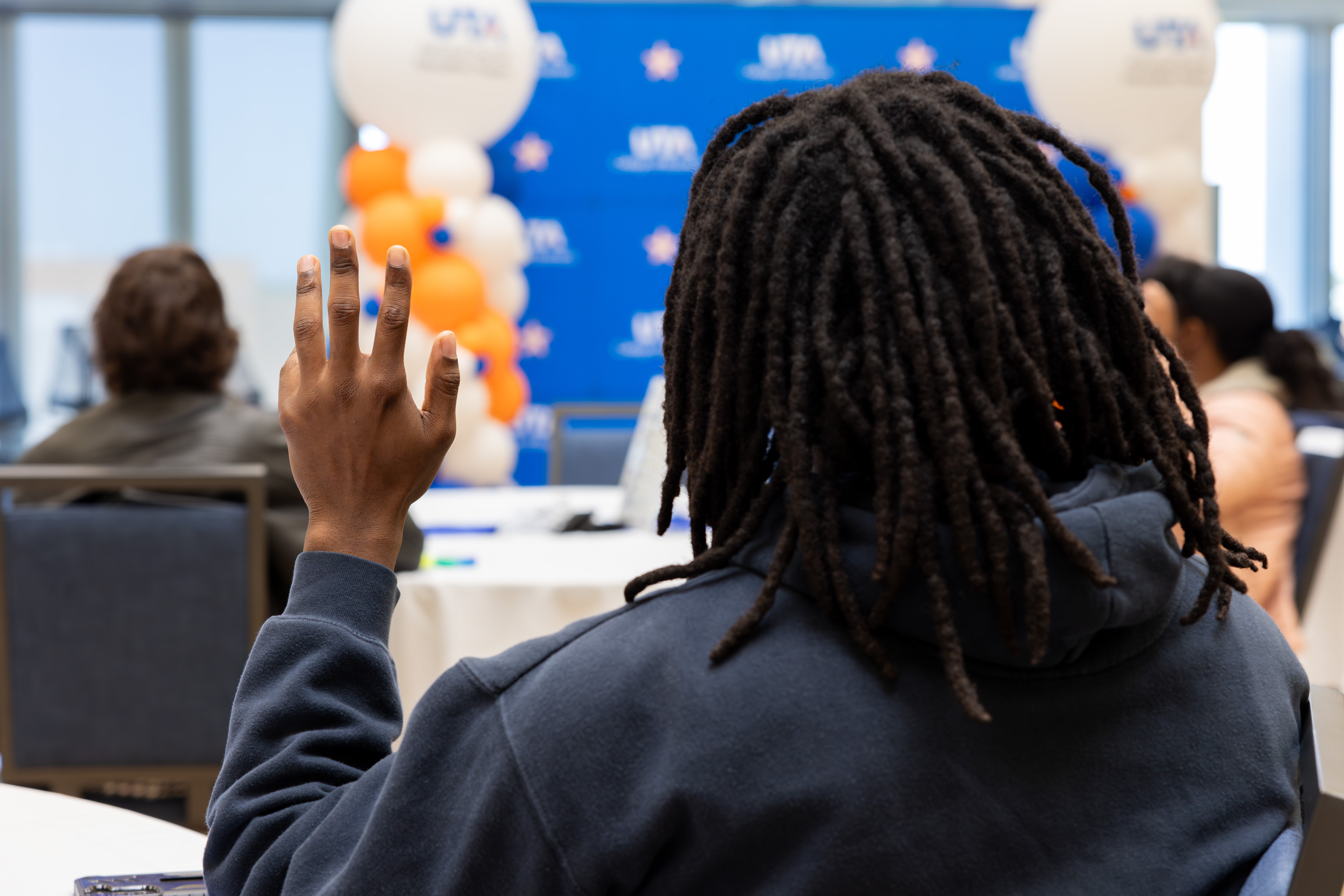 Student raises hand at event