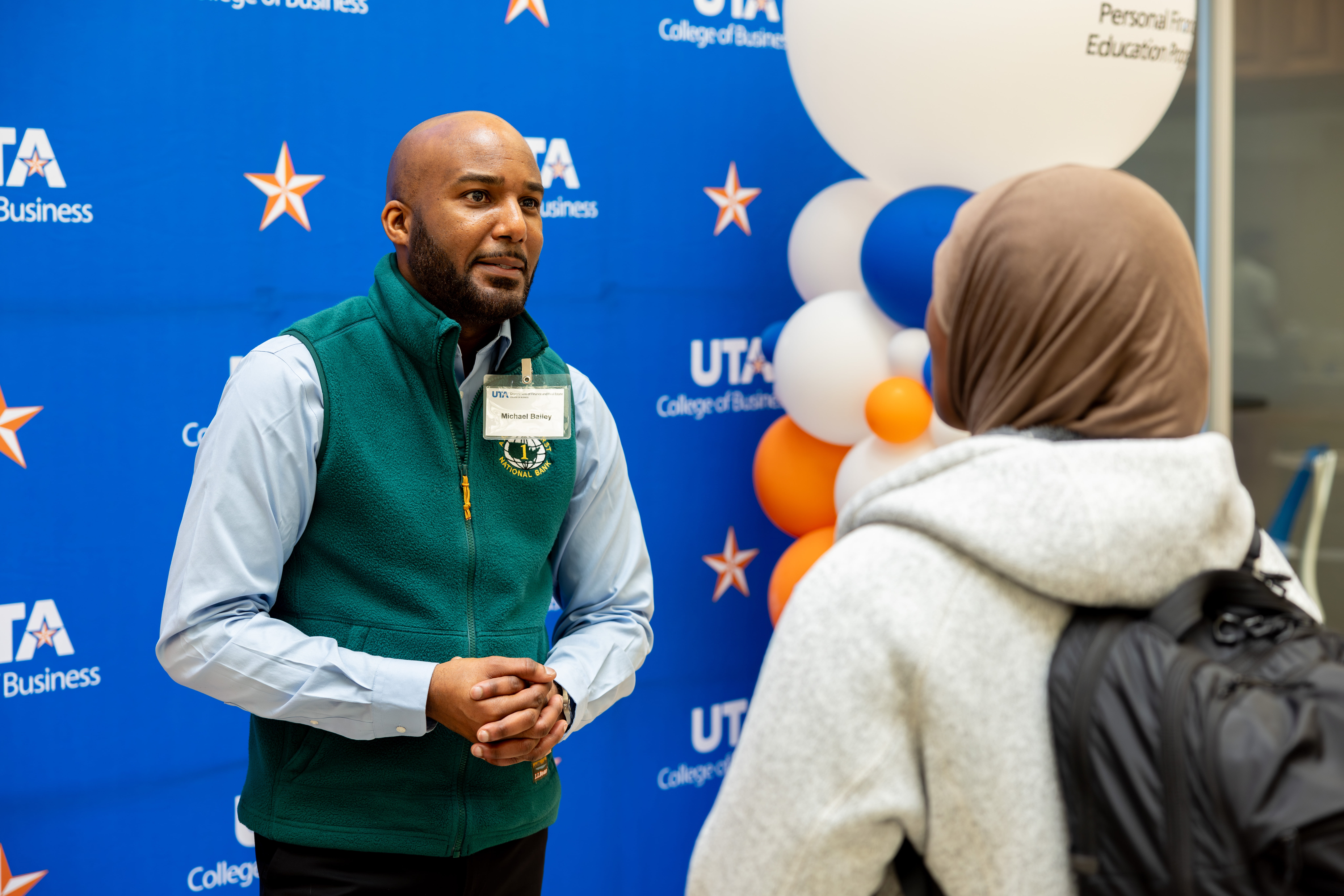 Man talks to college student at event