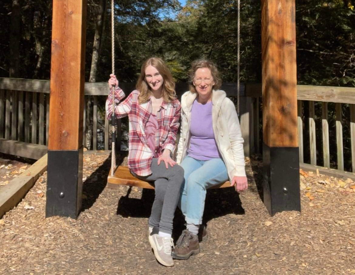Photo of Catherine Hinton with her daughter on a swing.