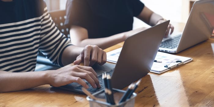 A person types on a laptop.