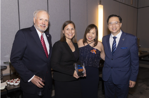 Group of professionals holding their MAVS100 award, smiling at camera.