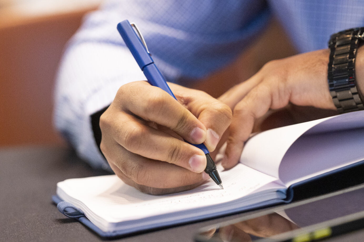 Man writing on a notepad.