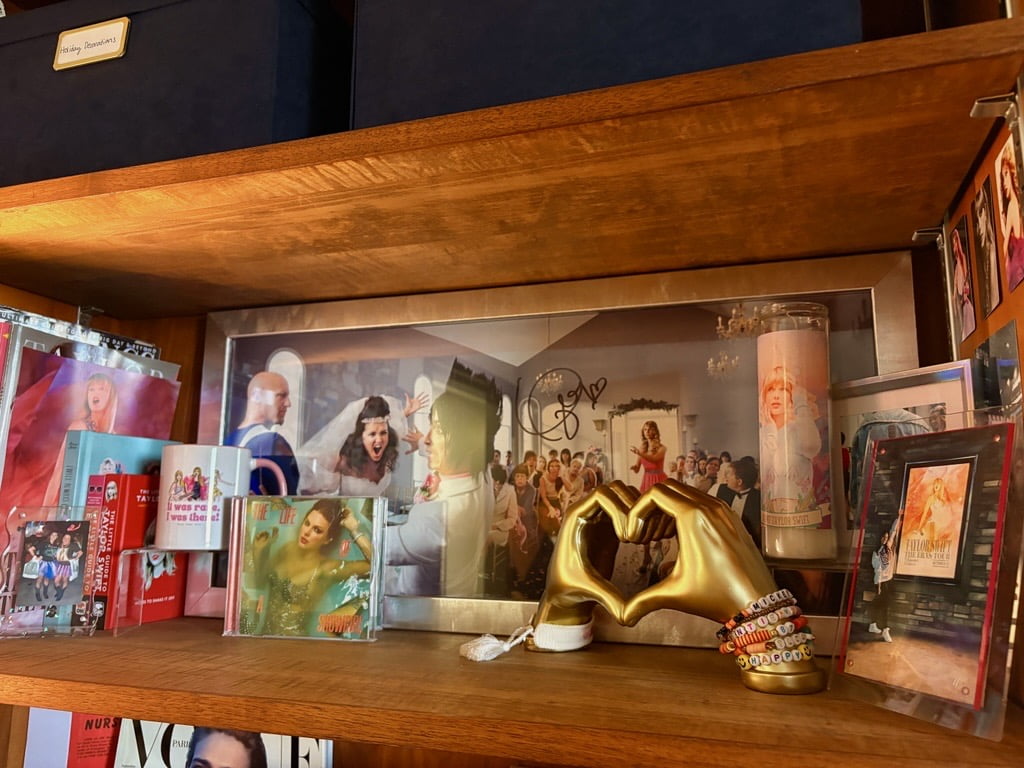 A shelf in Dr. Santee's office displaying multiple Taylor Swift related items.