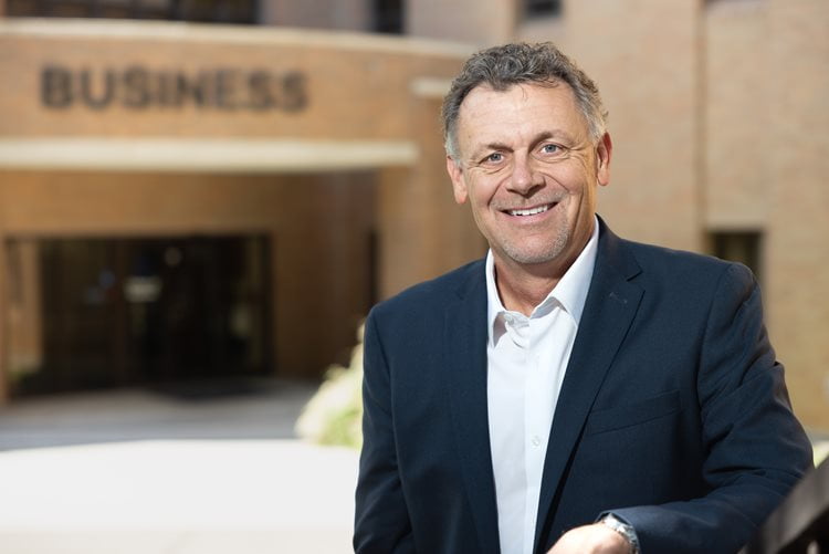 MSRE Graduate Advisor, Steve Isbell, poses for a photo in front of the UTA College of Business. (Photo by Jalen Larry)