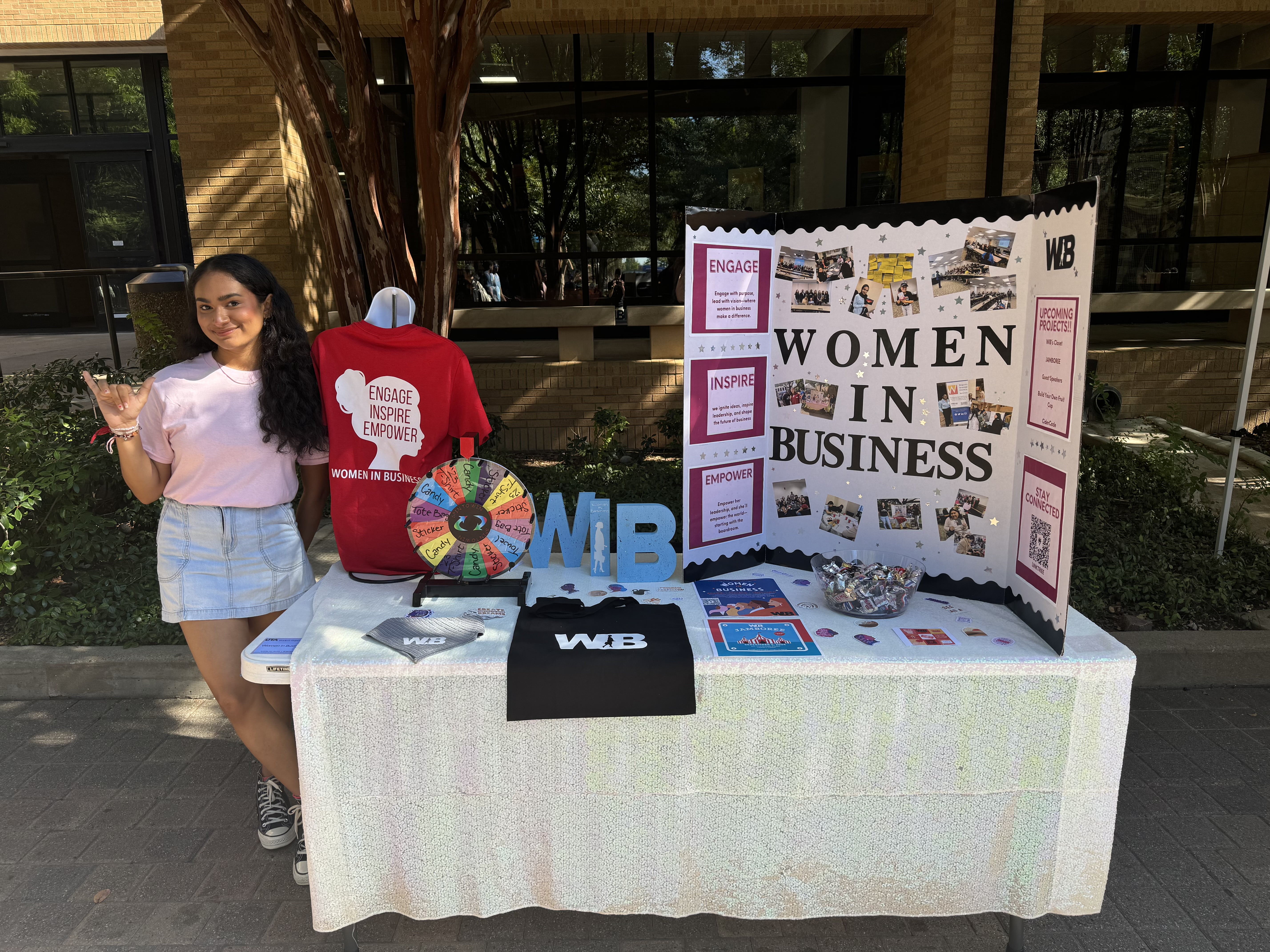 A member of the UTA Women in Business Student Organization poses for a photo beside a display for the organization. (Courtesy Photo)