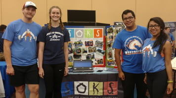 Society of Kinesiology Scholars in front of poster at event