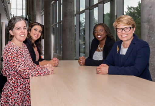 Gabriela Wilson sitting in a meeting with 3 other women