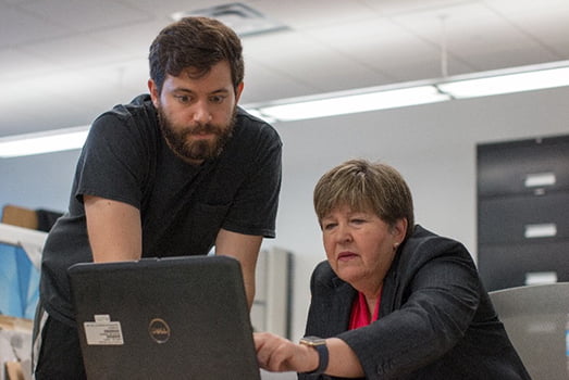 Kathy Daniel working in office with assistant