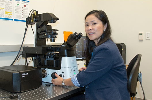 Zui Pan looking in microscope