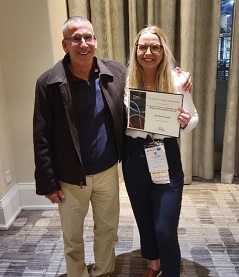 Paul Fadel standing with Anka Grotle holding her framed award