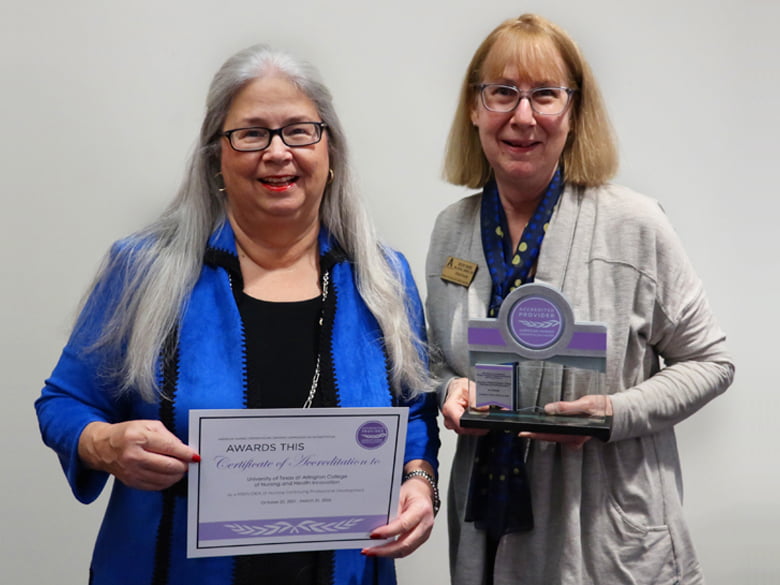 Dean Elizabeth Merwin and Dr. Becky Baird holding the reaccreditation certificate and award