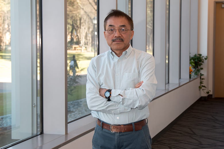 Dr. Yan Xiao standing in front of window