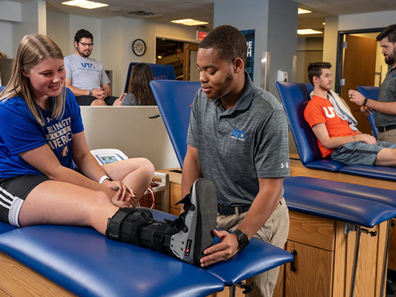 male tending the ankle of a girl on the bench