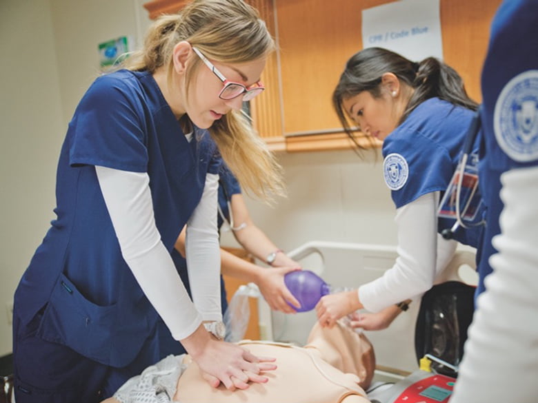 students giving CPR to mannequin