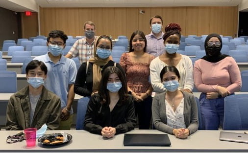 8 students in Surpint program standing in classroom with Dr. R. Brothers and Dr. Michael Nelson behind them.