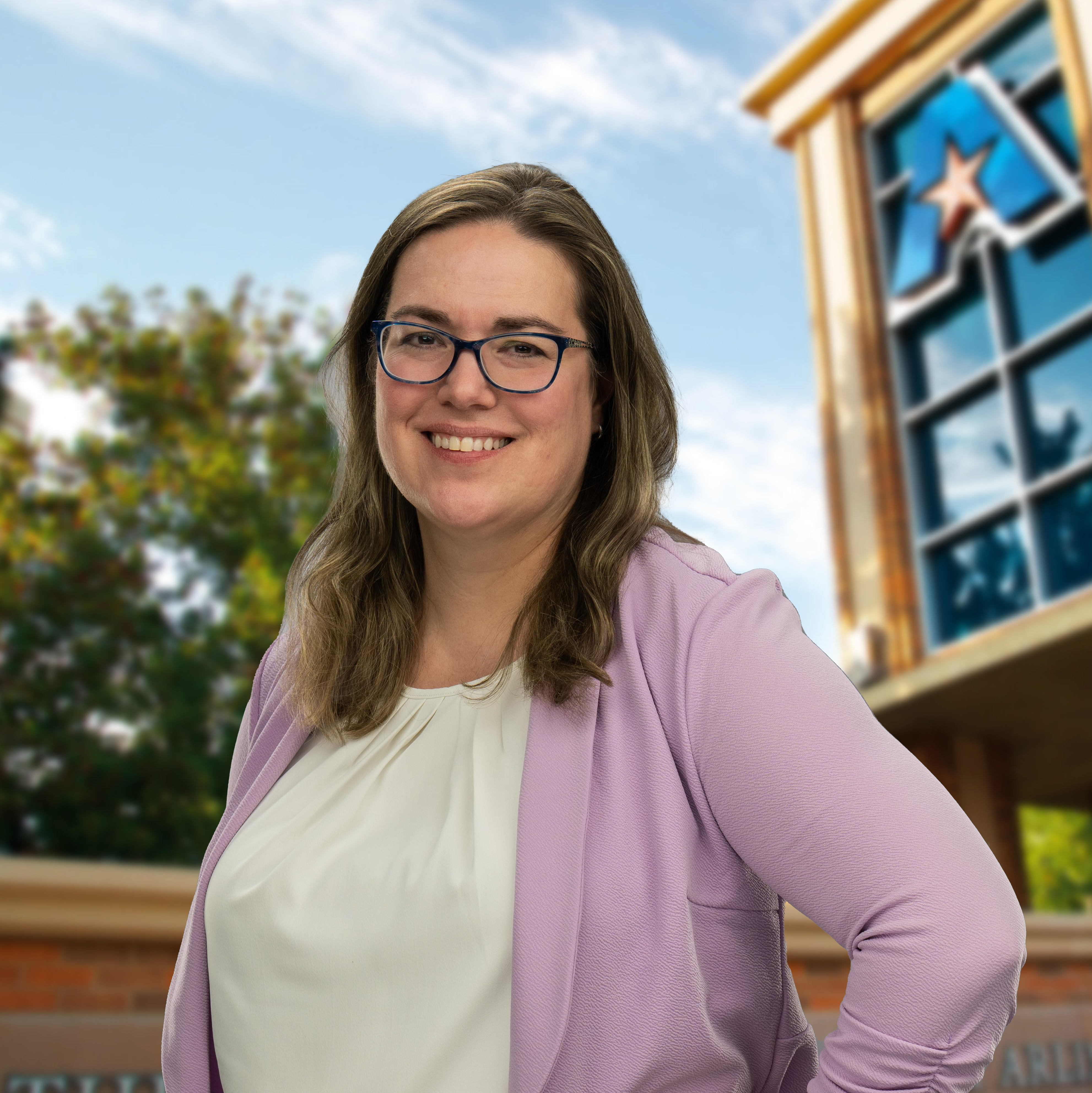 Headshot of University of Texas at Arlington employee Laura Penuel. The background shows a UTA campus sign.
