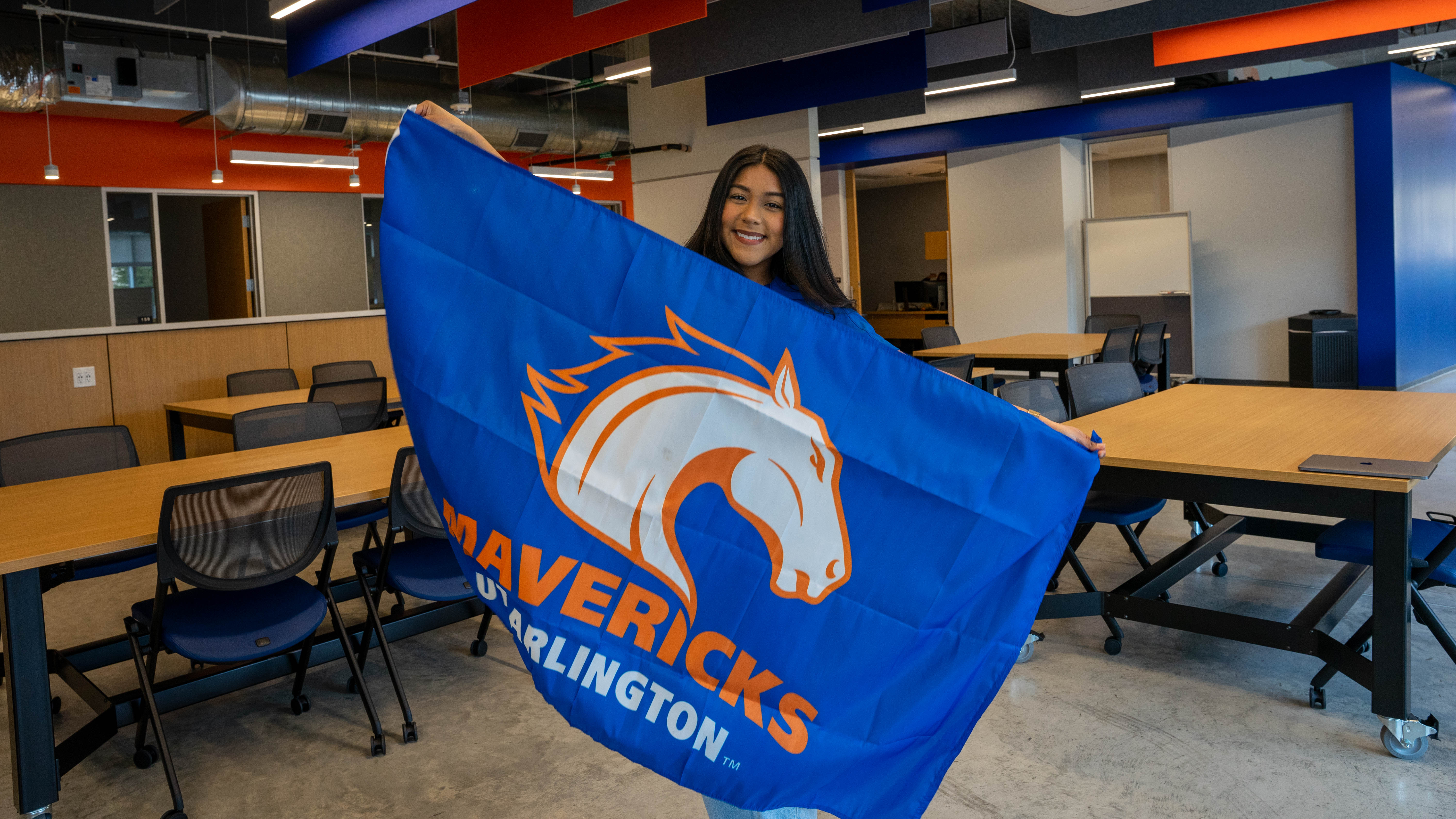 Irene Lopze holding the UTA school flag
