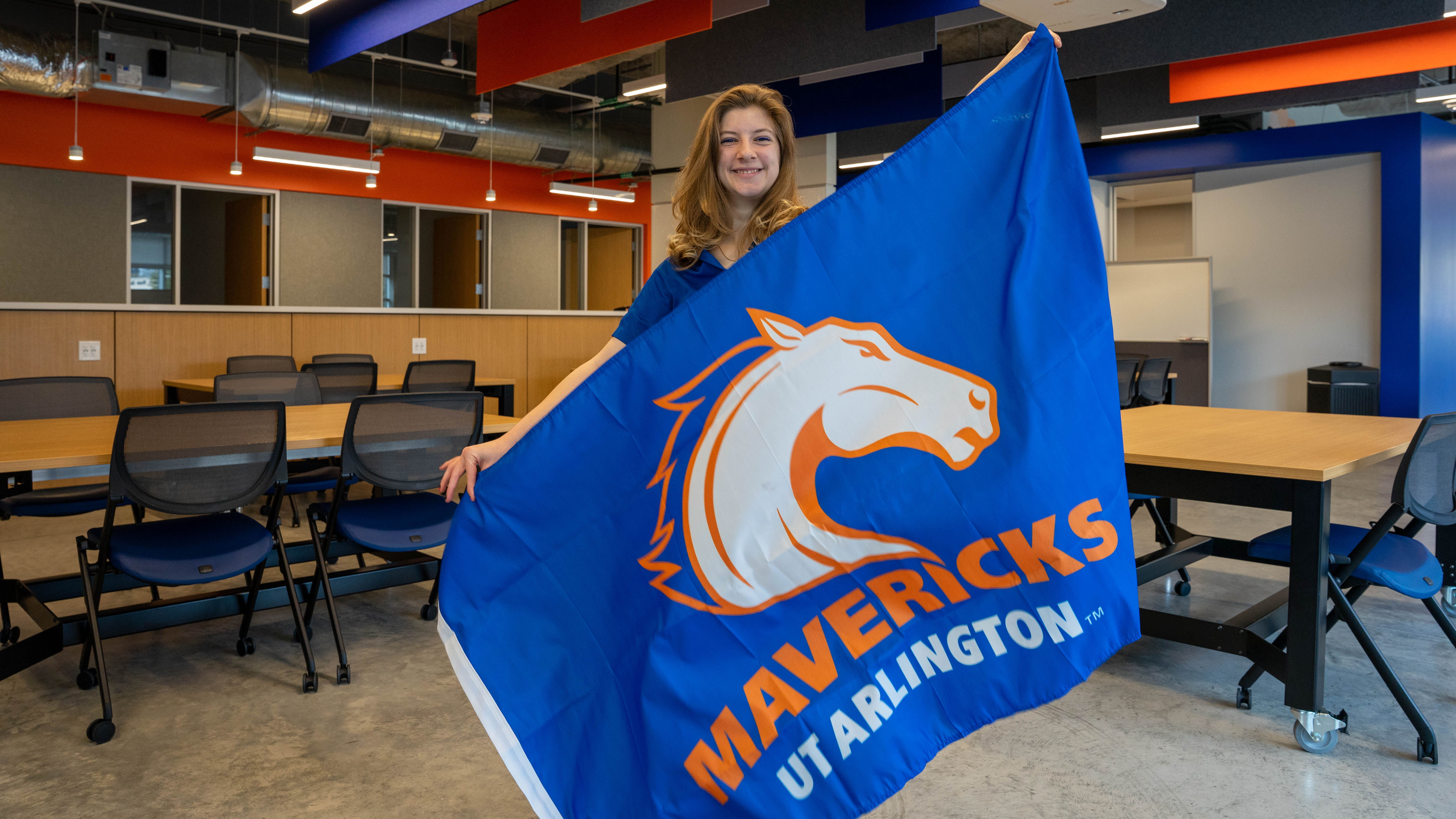 Julie Nickols holding the UTA school flag