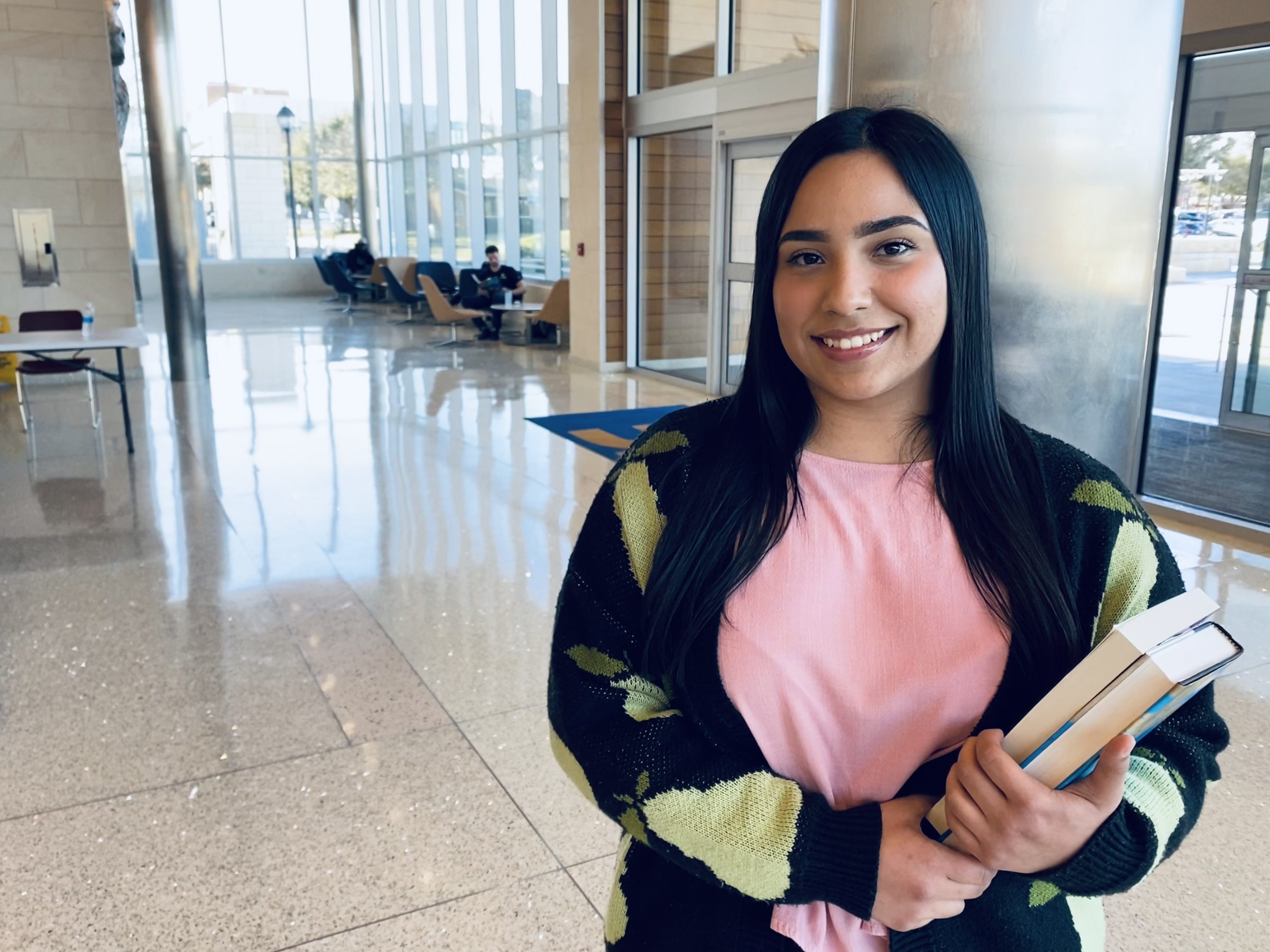 Student posing for a photo in the UC holding books