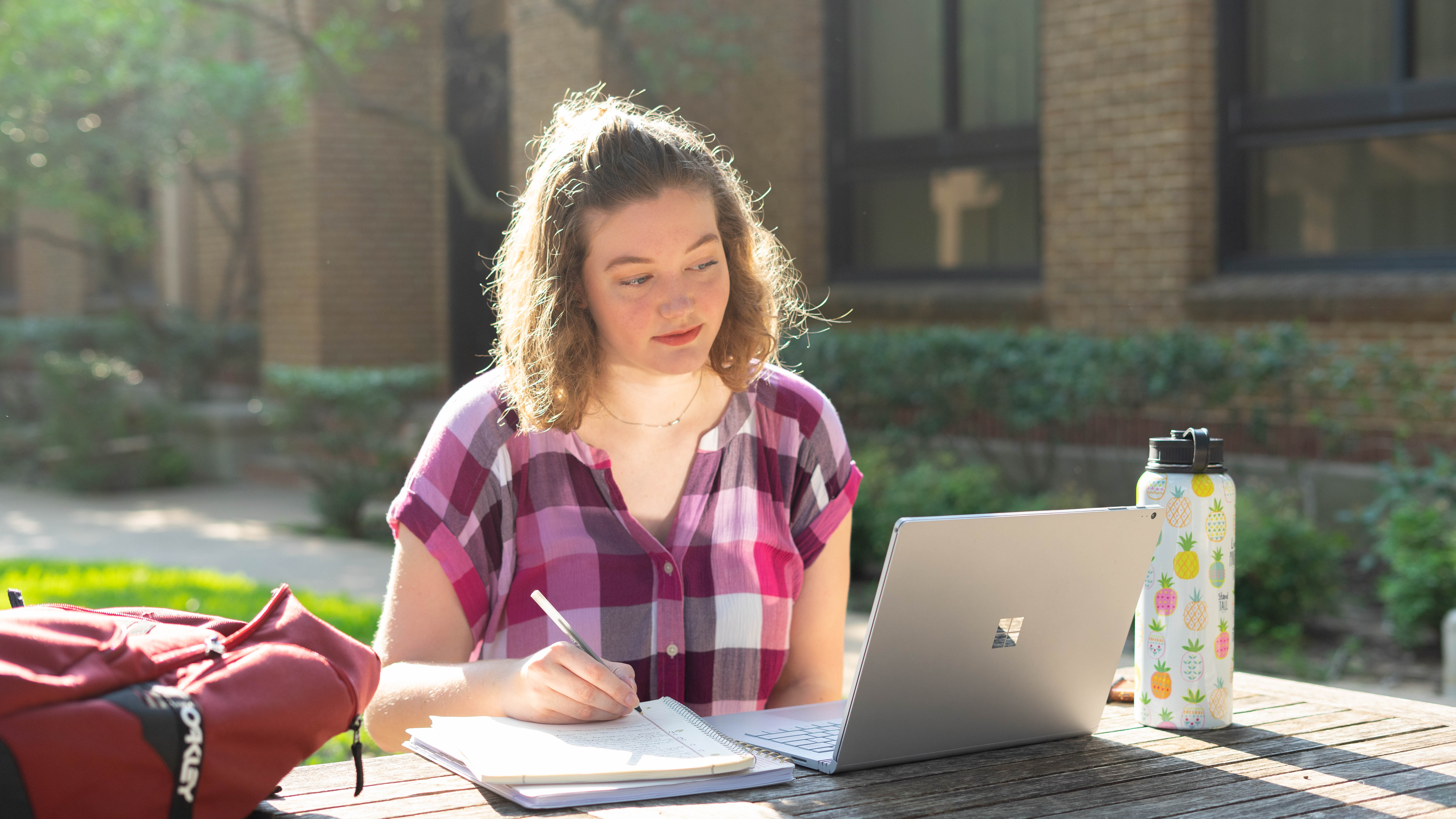 UTA Student Works on a Laptop on Campus