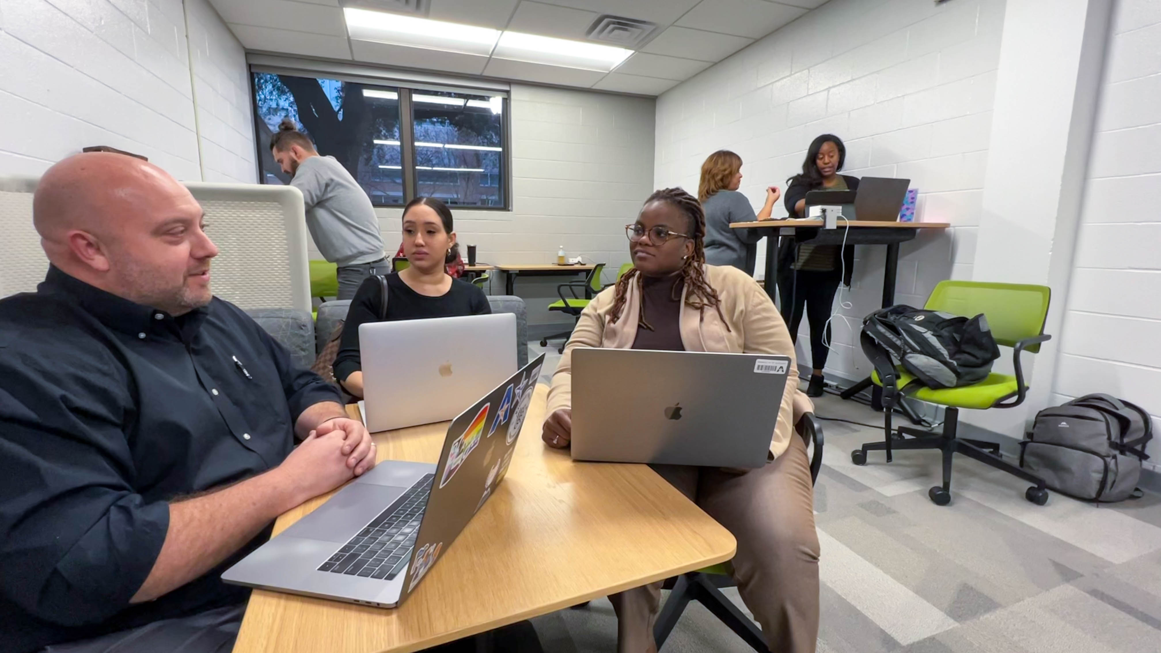 Ph.D. students at UTA work with a faculty member on assignments 