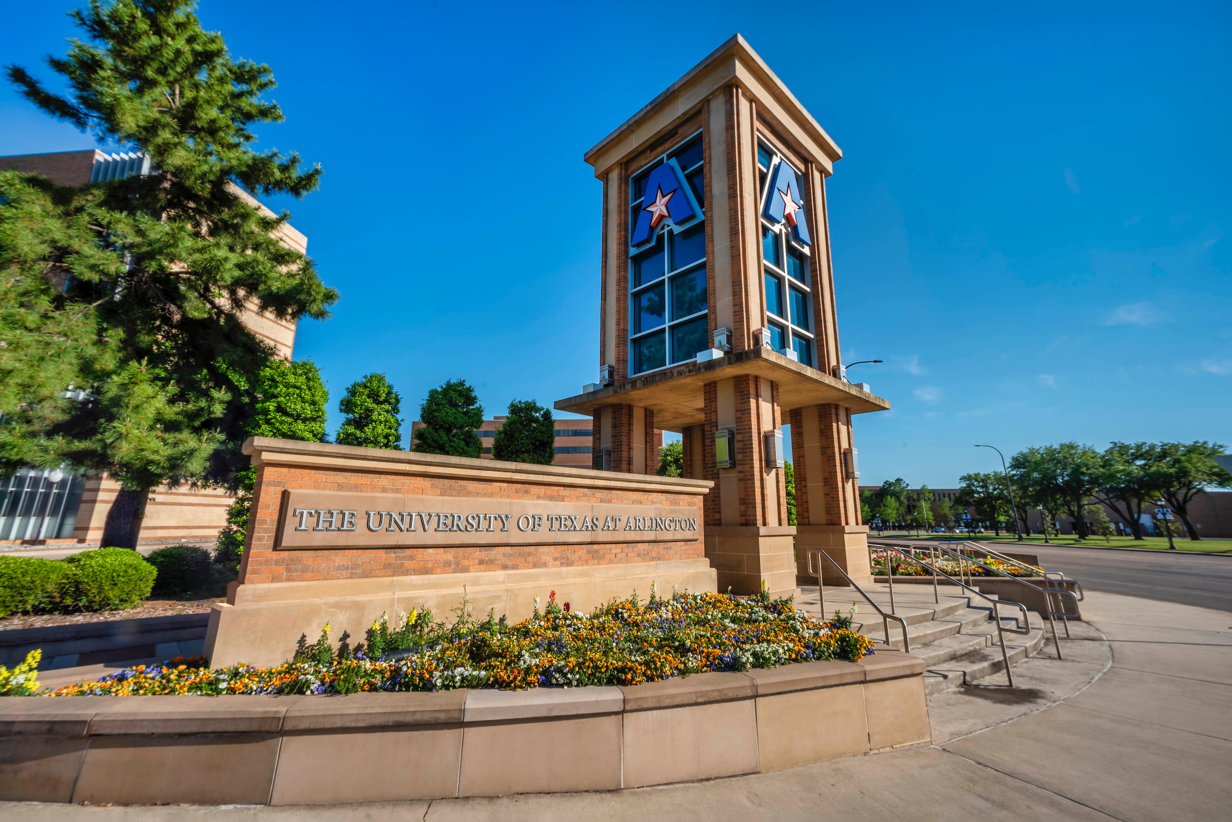 Outside photo of the University of Texas at Arlington campus sign and tower 