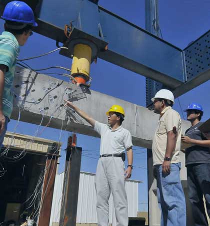 Civil engineering students studying concrete beams in the Civil Engineering laboratory.