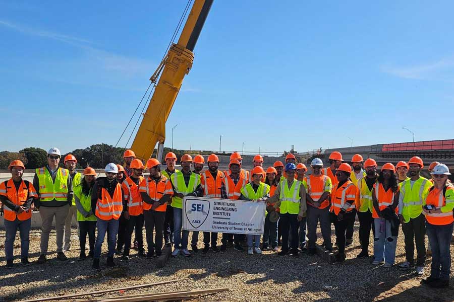 Many SEI students in front of a construction cherry picker.