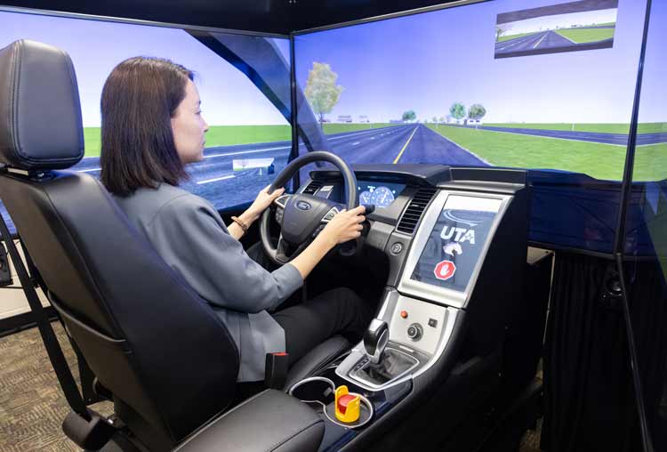 An individual sits in a driving simulator.