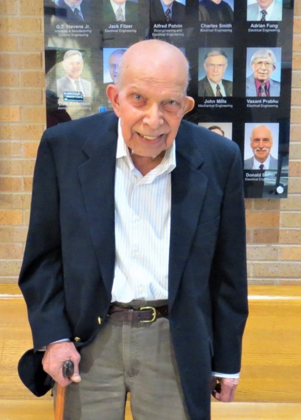 Professor Emeritus of Electrical Engineering Vasant Prabhu stands in front of the emeritus display in Nedderman Hall