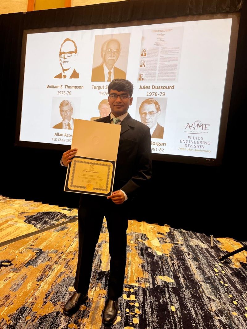 MAE student poses with award