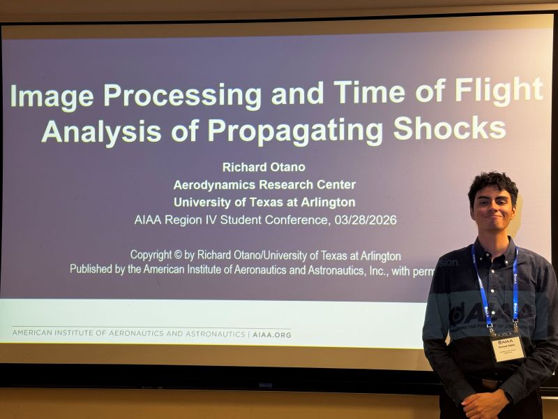 Student Richard Otano posing in front of Power Point presentation