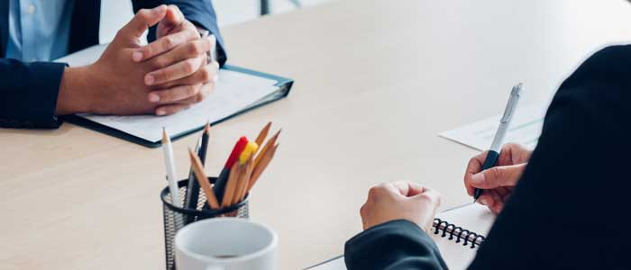 A person on an interview, sitting at a desk.