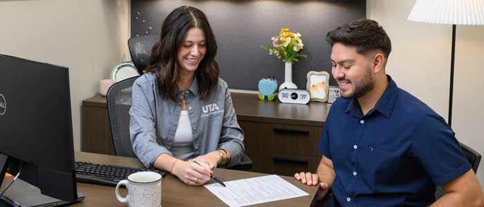 A person on an interview, sitting at a desk.