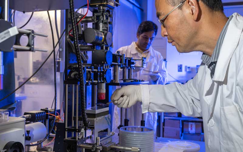 Dr Zhou in his lab with laboratory equipment.