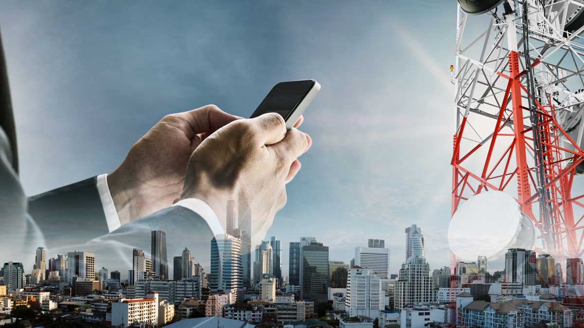 Graphic of a cellphone in a man's hands, a city skyline, and a cell tower.