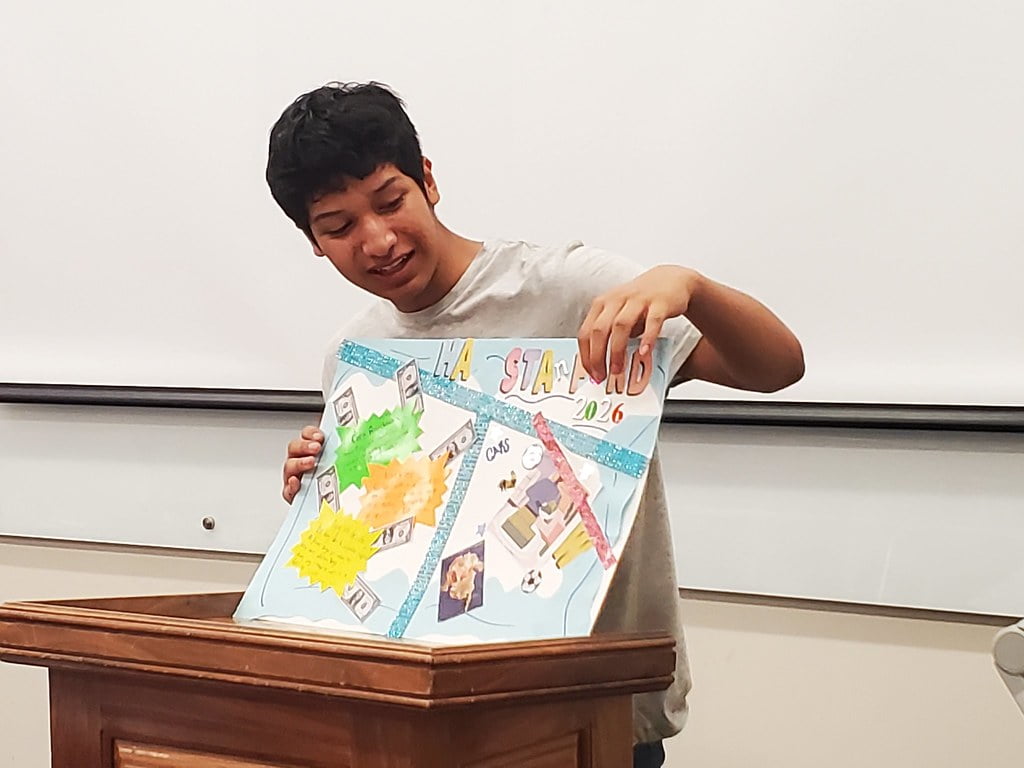 student showing his poster art work