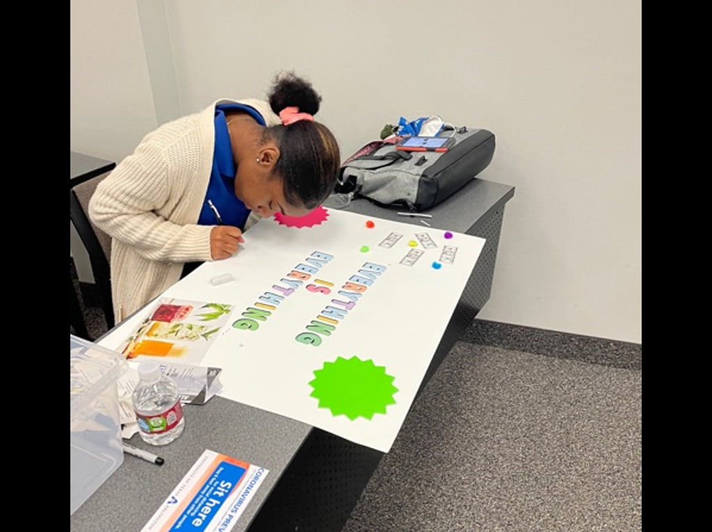 student designing on a poster board