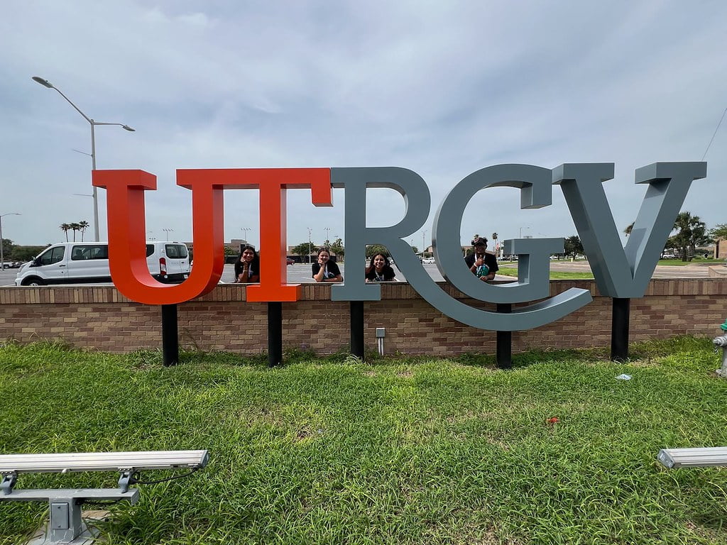 a group of students next to a university logo