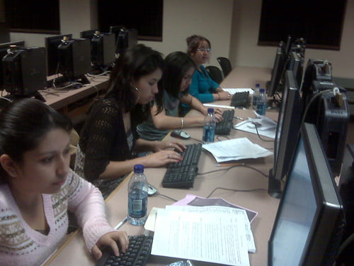 student typing on a computer