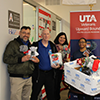 veterans upward bound holding a pair of new socks and showing a full box of new pair of socks.