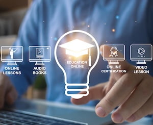 person with a blue shirt touching a glowing screen with a graduation cap