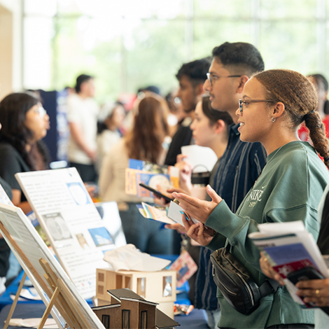 Student asking questions at a presentation