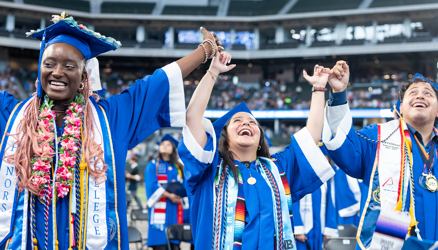Three Graduates hands raised in triumph