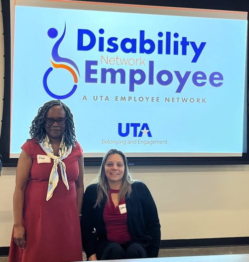 photograph of two female employees in front of a screen that reads disability employee